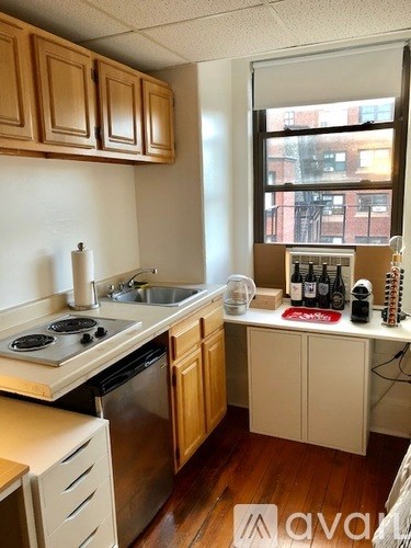A kitchen with wooden cabinets and a window overlooking a city.
