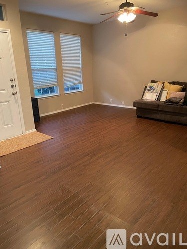 A room with wooden flooring and a ceiling fan.