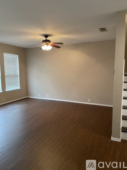 A room with wooden floors and a ceiling fan.
