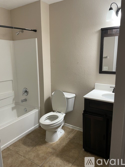 A bathroom with a toilet, sink, and bathtub.