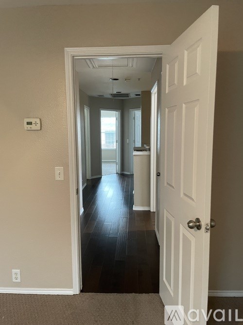 A hallway with a white door and a carpeted floor.