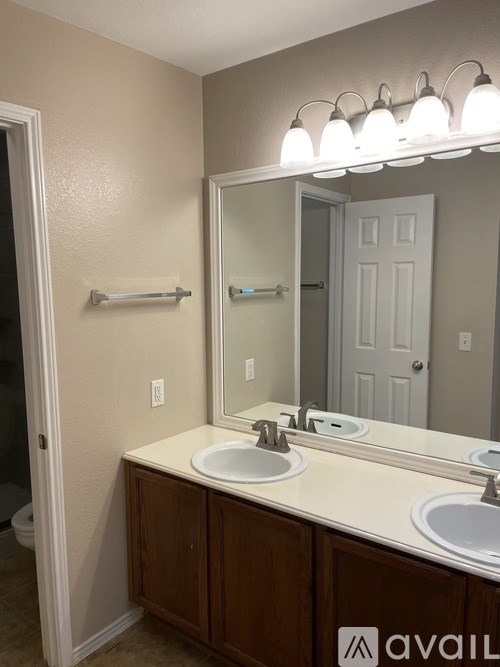 A bathroom with a double sink and a mirror above it.