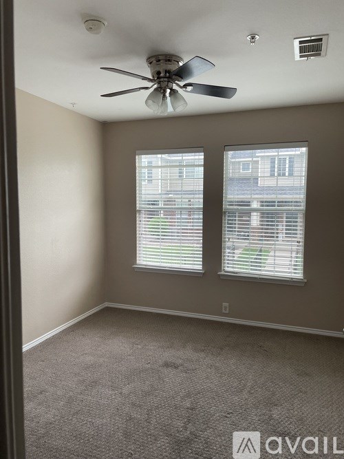 A room with a ceiling fan and carpeted floor.