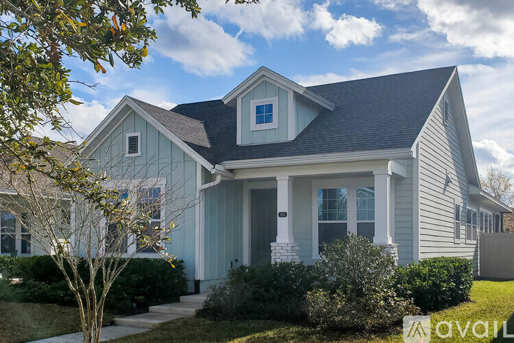 A house with a blue front door and a tree in front of it.
