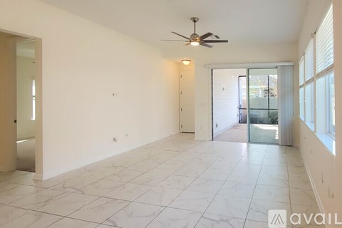 A spacious room with a ceiling fan and marble flooring.