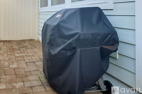 A grill is covered with a black tarp.