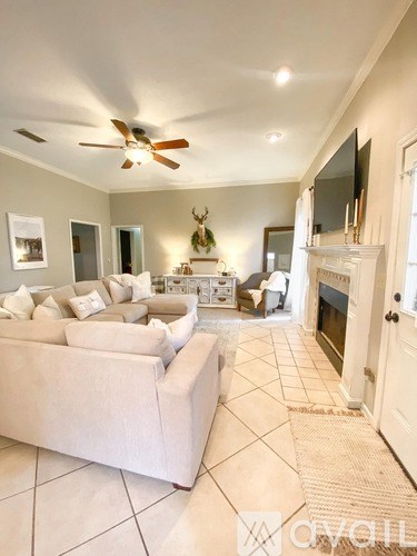 A living room with a white couch and a ceiling fan.