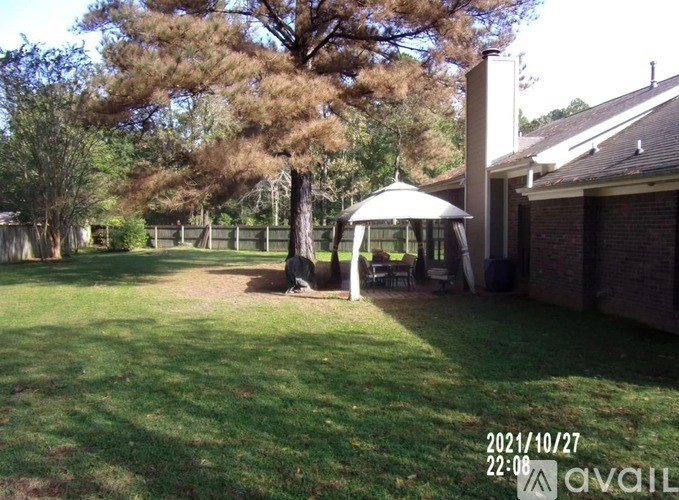 A gazebo is in the middle of a grassy yard.