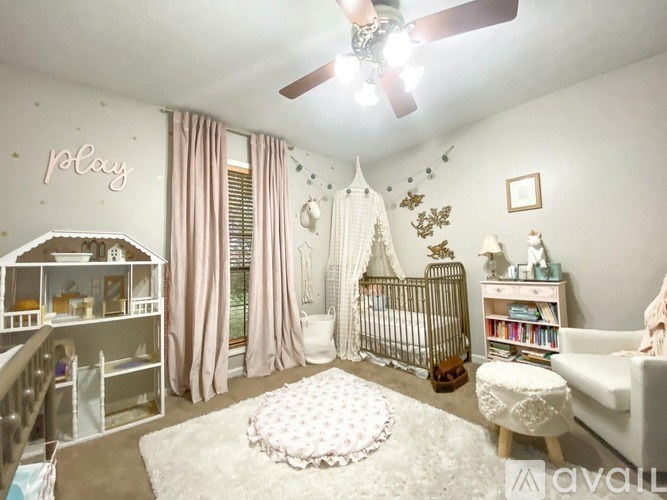 A baby nursery with a white crib, a white chair, and a white rug.