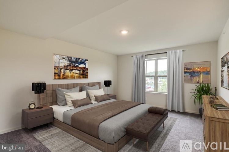 A bedroom with a large bed and a painting on the wall.