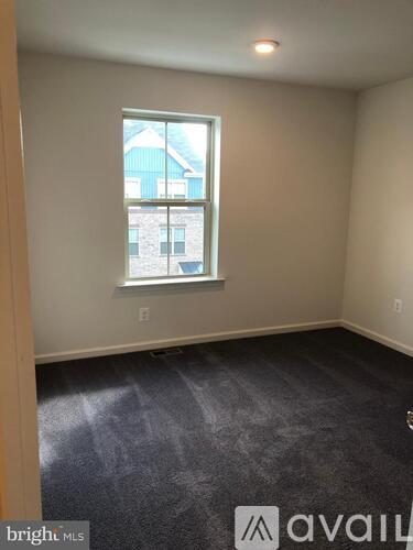 A room with a window and a view of a building outside.