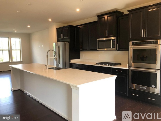 A kitchen with black cabinets and stainless steel appliances.