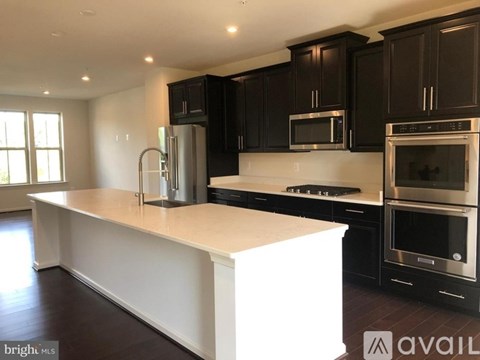 A kitchen with black cabinets and stainless steel appliances.