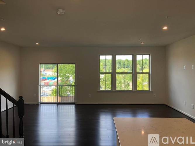 A spacious room with a balcony and large windows.