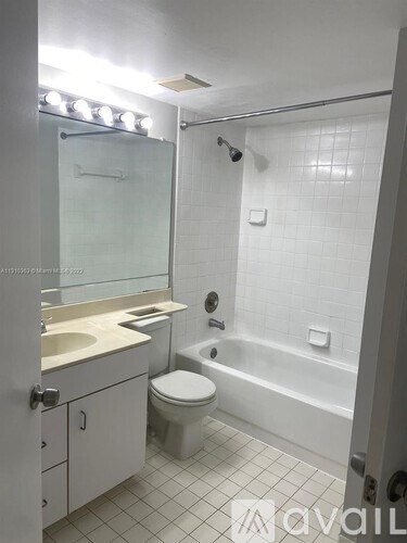 A white bathroom with a toilet, sink, and bathtub.