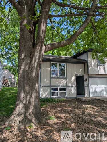 A tree is in front of a house.