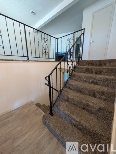 A staircase with a metal railing and a carpeted floor.