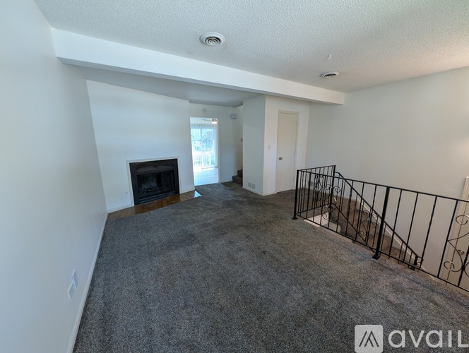 A living room with a fireplace and carpeted floor.