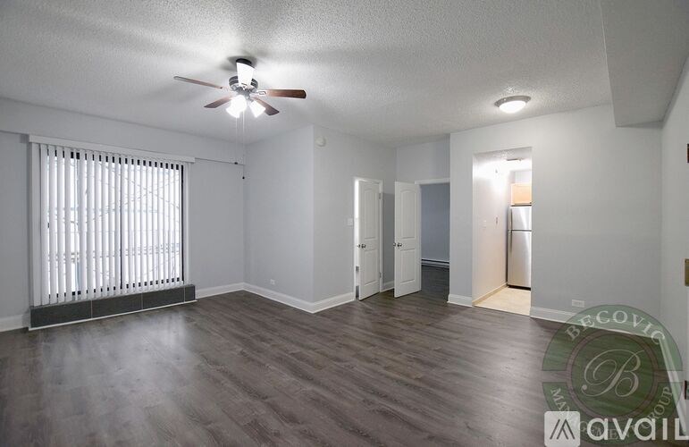 A room with a ceiling fan and wooden flooring.