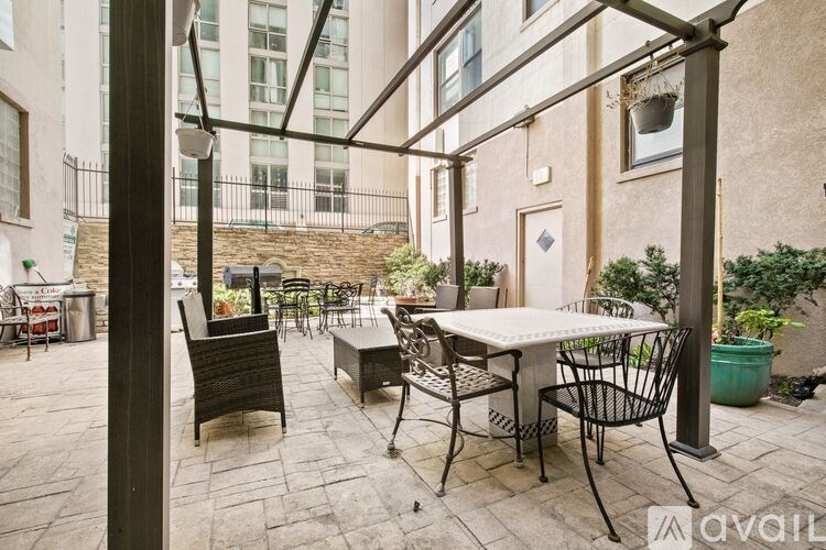 A patio with a table and chairs is covered by a roof.