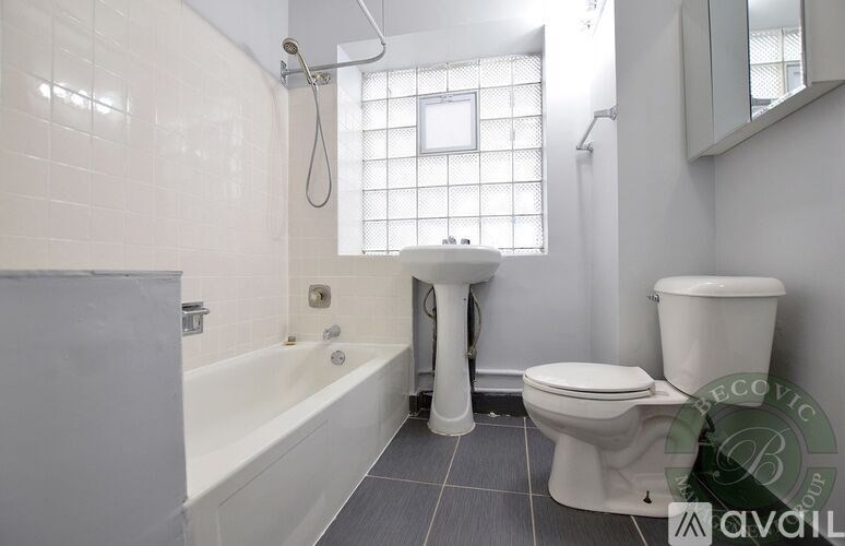 A white toilet sits next to a white sink in a bathroom.