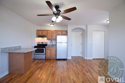 A kitchen with wooden floors and a ceiling fan.