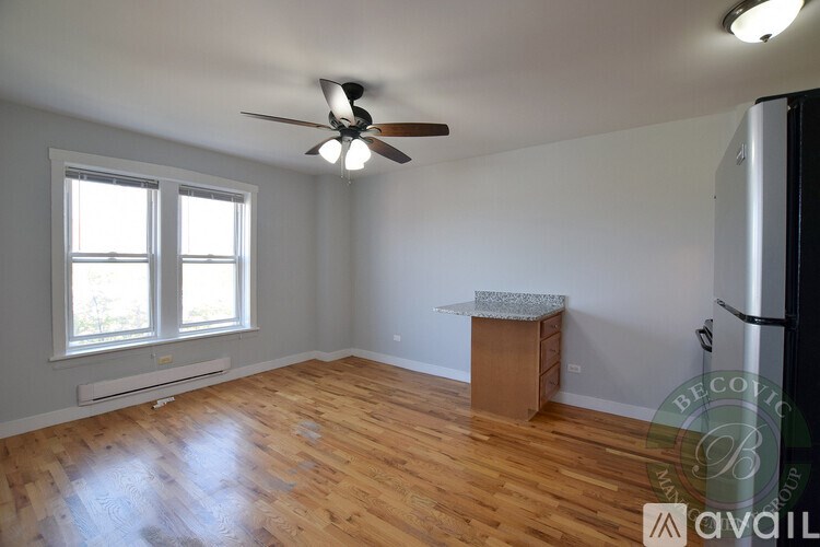 A room with a ceiling fan and wooden flooring.