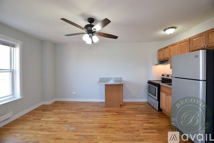 A kitchen with wooden floors and a ceiling fan.