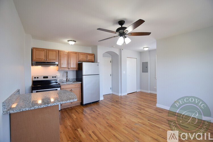 A kitchen with wooden cabinets and a white refrigerator is available for rent.