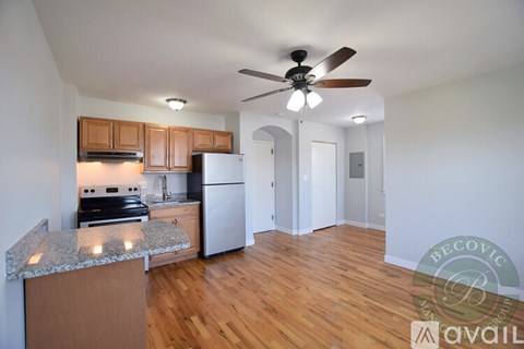 A kitchen with wooden cabinets and a white refrigerator is available for rent.