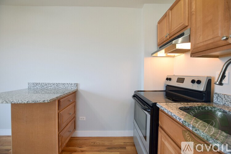 A kitchen with wooden cabinets and a granite countertop.