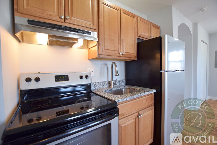 A kitchen with a black stove top oven and black refrigerator.
