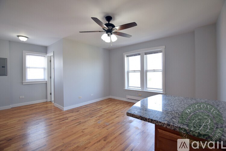 A room with a ceiling fan and wooden flooring.