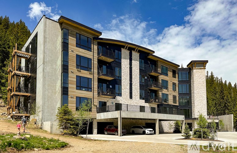 A modern concrete building with a balcony and a carport.