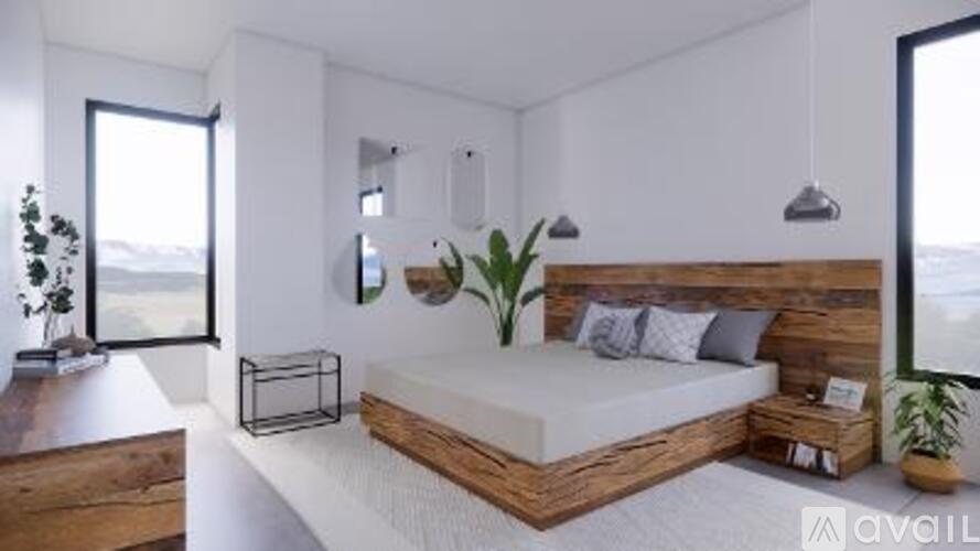 A bedroom with a bed, nightstand, and a plant.