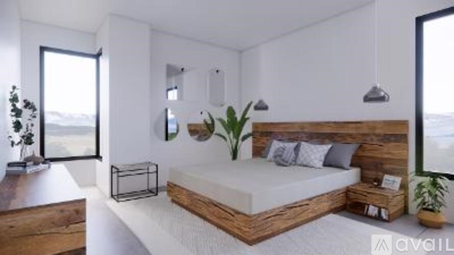 A bedroom with a bed, nightstand, and a plant.