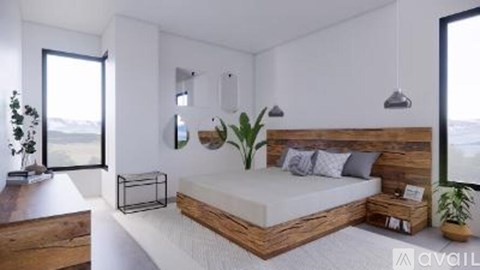 A bedroom with a bed, nightstand, and a plant.