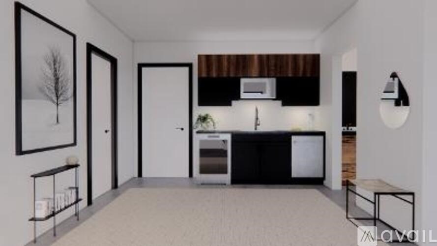 A modern kitchen with white walls and a black fridge.