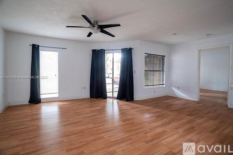 A room with wooden flooring and a ceiling fan.