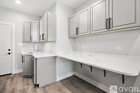 A kitchen with white cabinets and a white countertop.