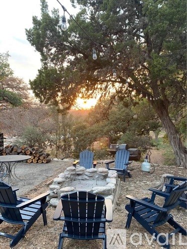 A sunset view of a backyard with a table and chairs.