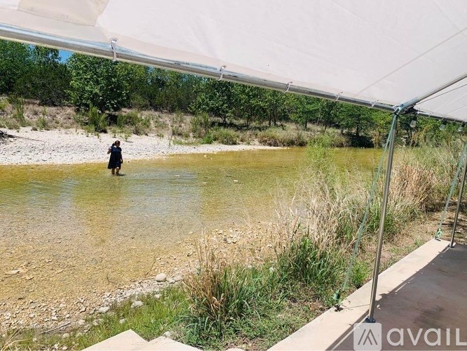 A person is standing in a river under a white canopy.