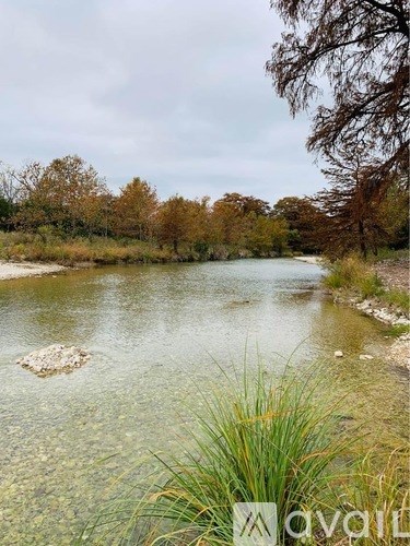 A river flows through a natural landscape with trees and grass.