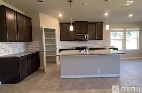 A kitchen with brown cabinets and a white brick backsplash.