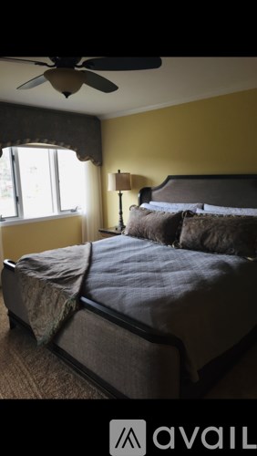 A bedroom with a bed and a ceiling fan.