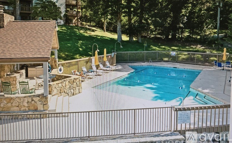 A pool surrounded by a fence and trees.