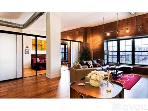 A living room with a wooden floor and a brick wall.