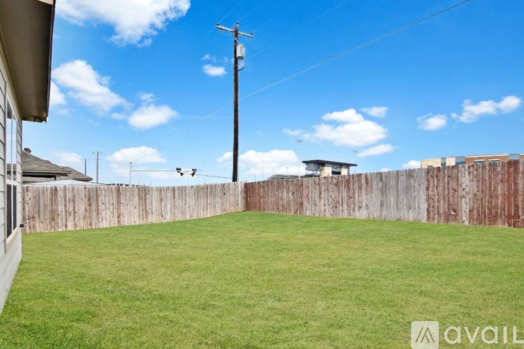 A backyard with a wooden fence and a grassy area.