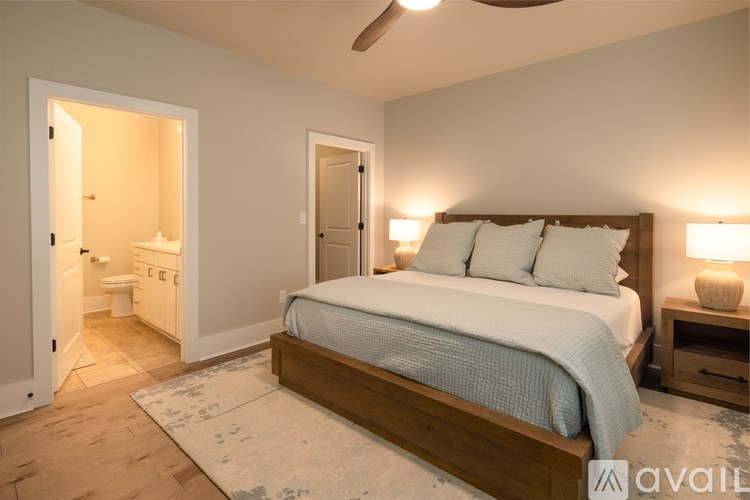 A bedroom with a large bed and a ceiling fan.