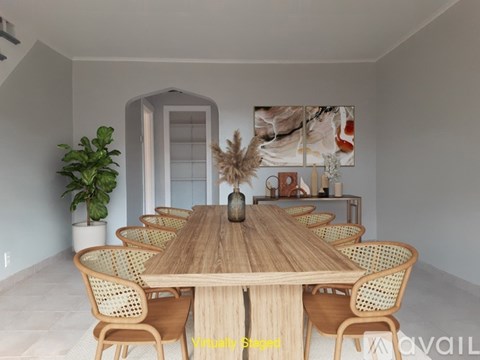 A dining room with a wooden table and chairs.